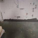 Basement wall showing structural repair work with reinforced sections and a clean floor, illustrating the foundation repair process by Toledo Basement Repair.