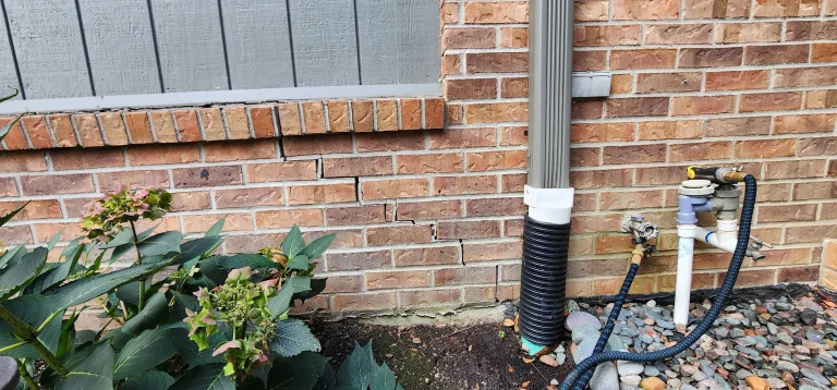 Settling garage foundation with brick cracks in Perrysburg Ohio before helical pier installation